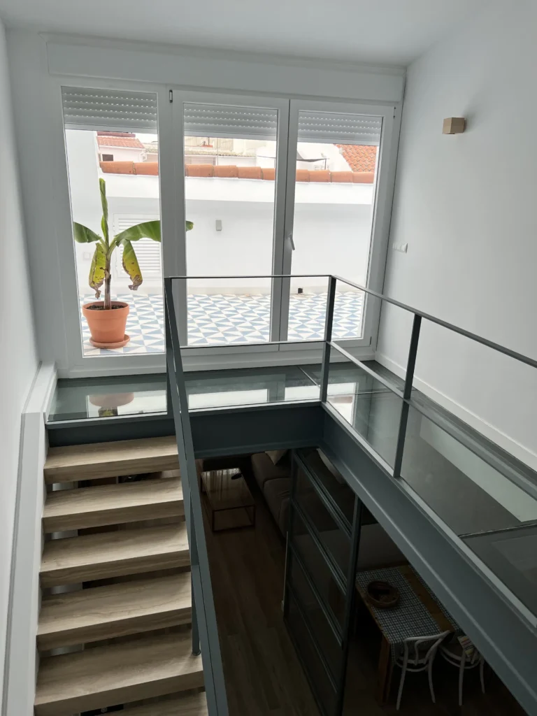 Escalera con suelo de cristal e iluminación en el rodapié